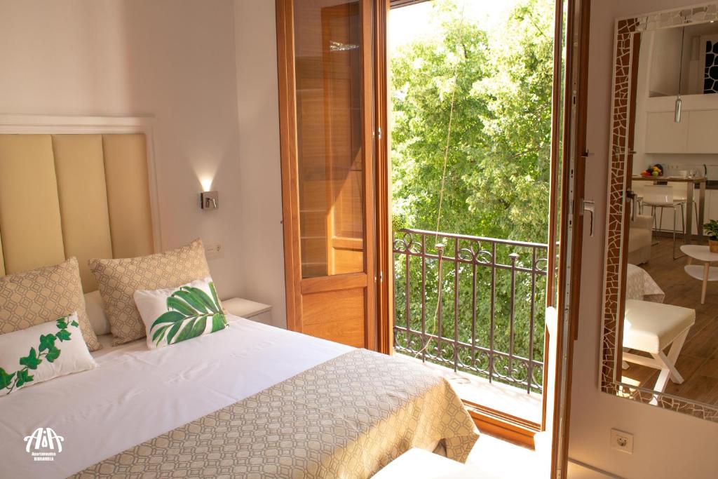 a bedroom with a bed and a balcony at AiA LOFT BIBRAMBLA in Granada