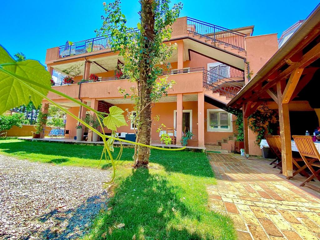 a house with a tree in front of it at Apartments Tajana in Novigrad Istria