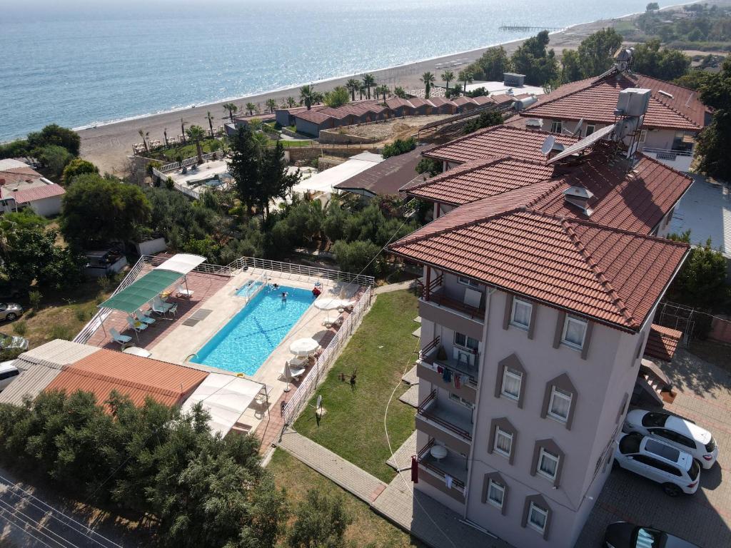 an aerial view of a building with a swimming pool and the beach at Sercan Apart in Kızılot