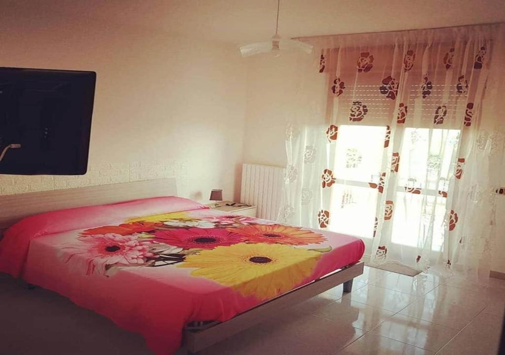 una camera con un letto con una coperta floreale di Vista Volo a Pontecagnano