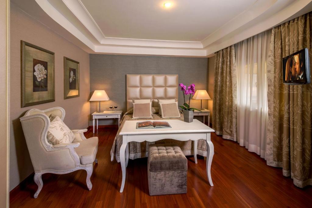 uma sala de estar com uma mesa e duas cadeiras em Hotel Piccolo Borgo em Roma