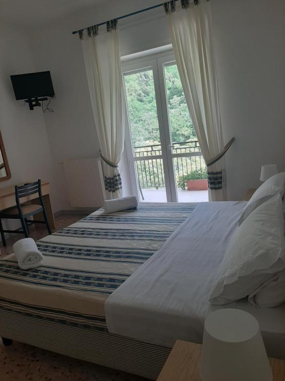 a bedroom with a large bed and a large window at Hotel Parco Delle Rose in Acquappesa