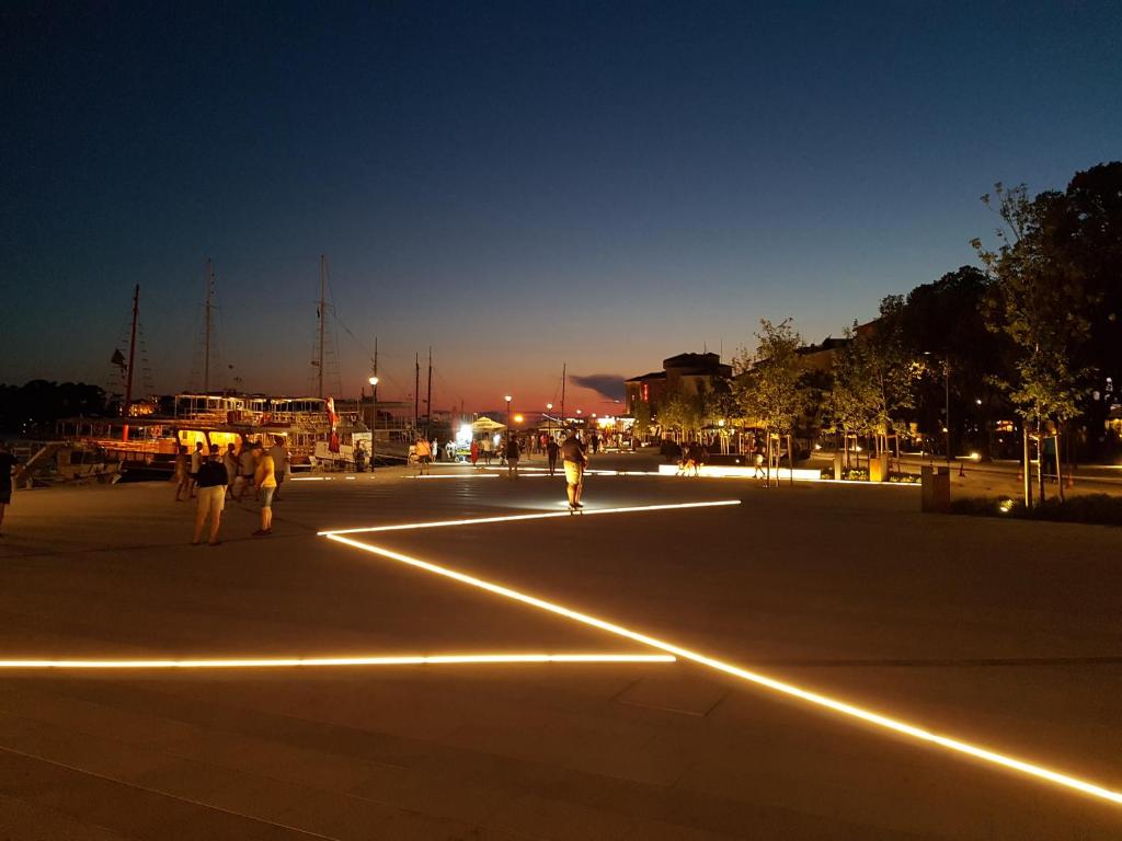 a group of people standing in a parking lot at night at Poreč old town, apartments in Poreč