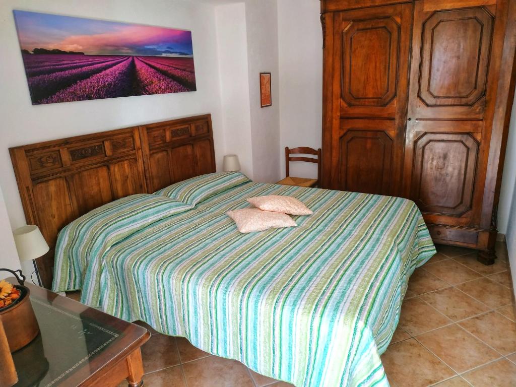 a small bedroom with a bed with a wooden headboard at Da Miki in Chiomonte