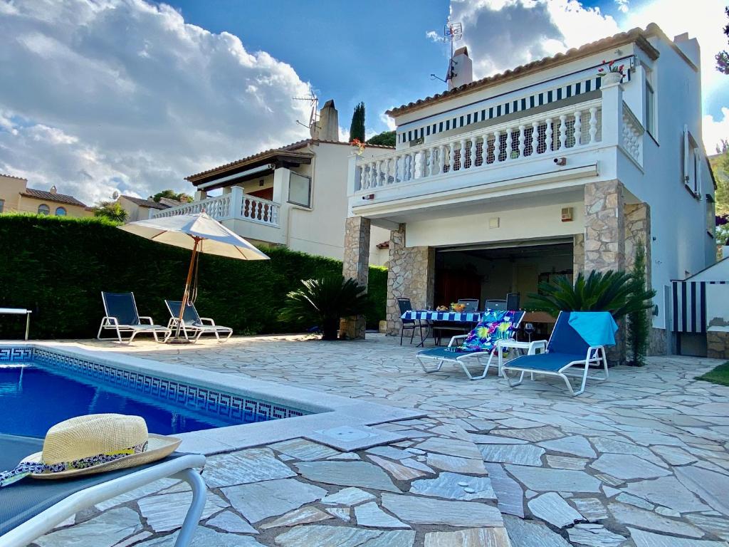 uma casa com piscina ao lado de um edifício em Torre Vella em L'Estartit