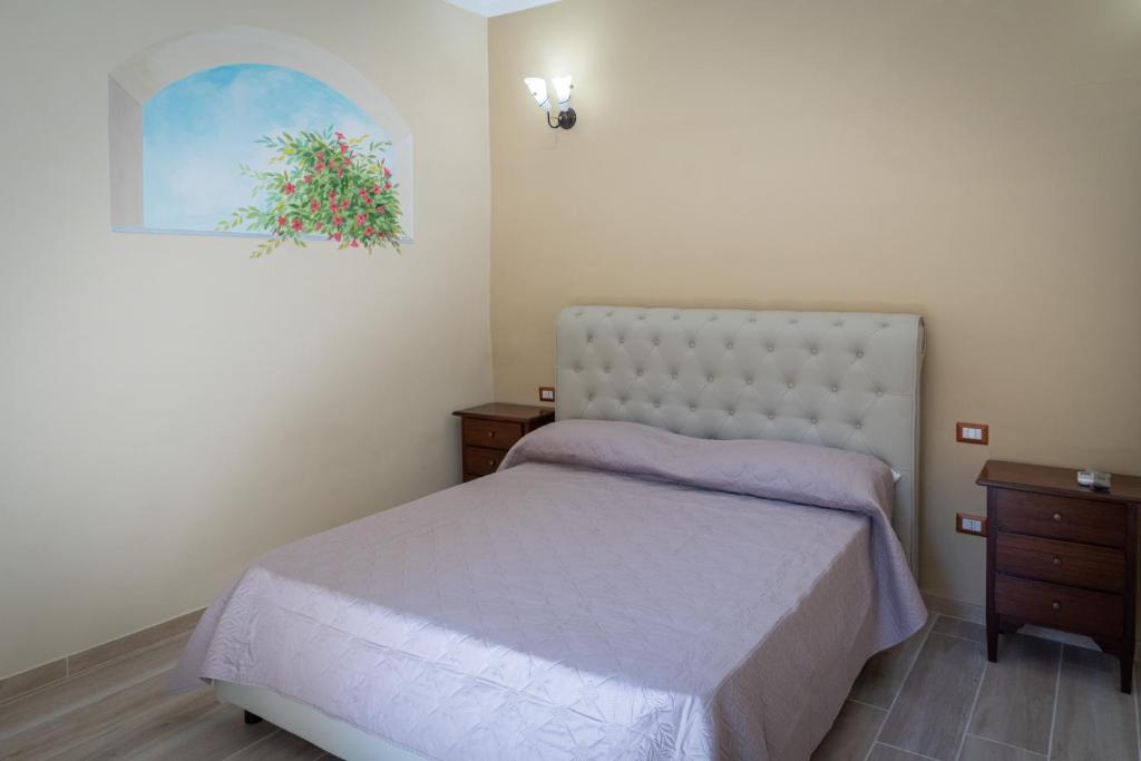 1 dormitorio con 1 cama y una pintura en la pared en Mandevilla Home en Caiazzo