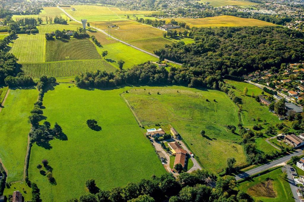 z góry widok na park z zieloną trawą i drzewami w obiekcie Logis Hôtel Corintel Bordeaux Est w mieście Tresses