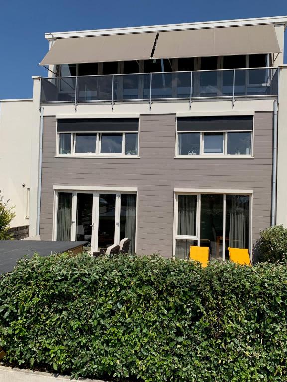 a building with yellow chairs in front of it at Zilvermeeuw - Drieplassenweg in Katwijk