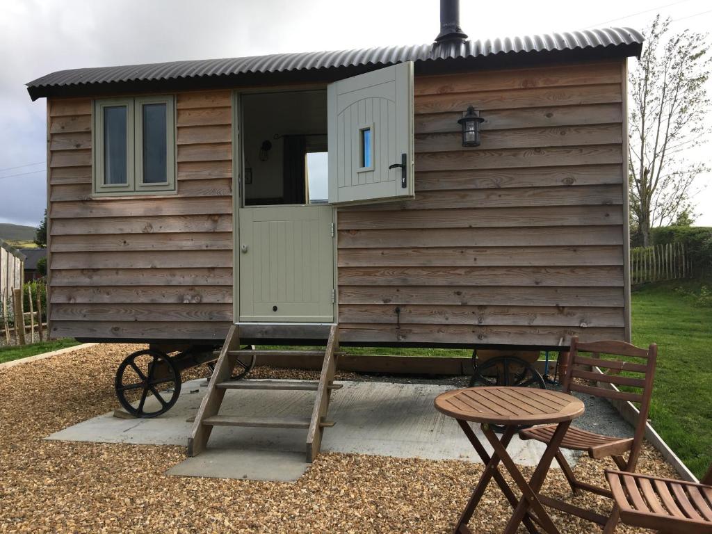 a cabin with a ladder and a table and a bench at 40 Bernisdale - Shepherds Hut in Skeabost