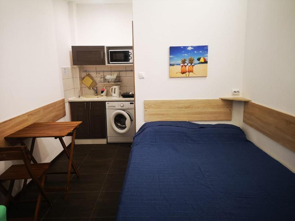 アドレルにあるСириус Апартのベッドとキッチン付きの小さな部屋