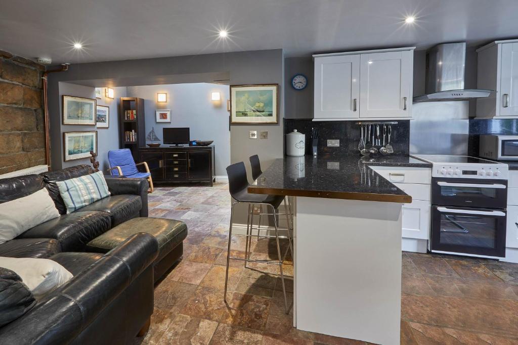 a kitchen and living room with a couch and a table at Host & Stay - Brunswick Cottage in Staithes