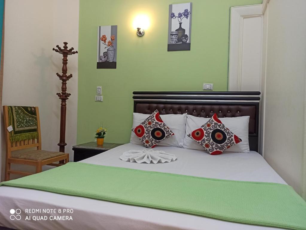 Cama con sábanas y almohadas rojas y verdes en Golden Star Hostel en El Cairo