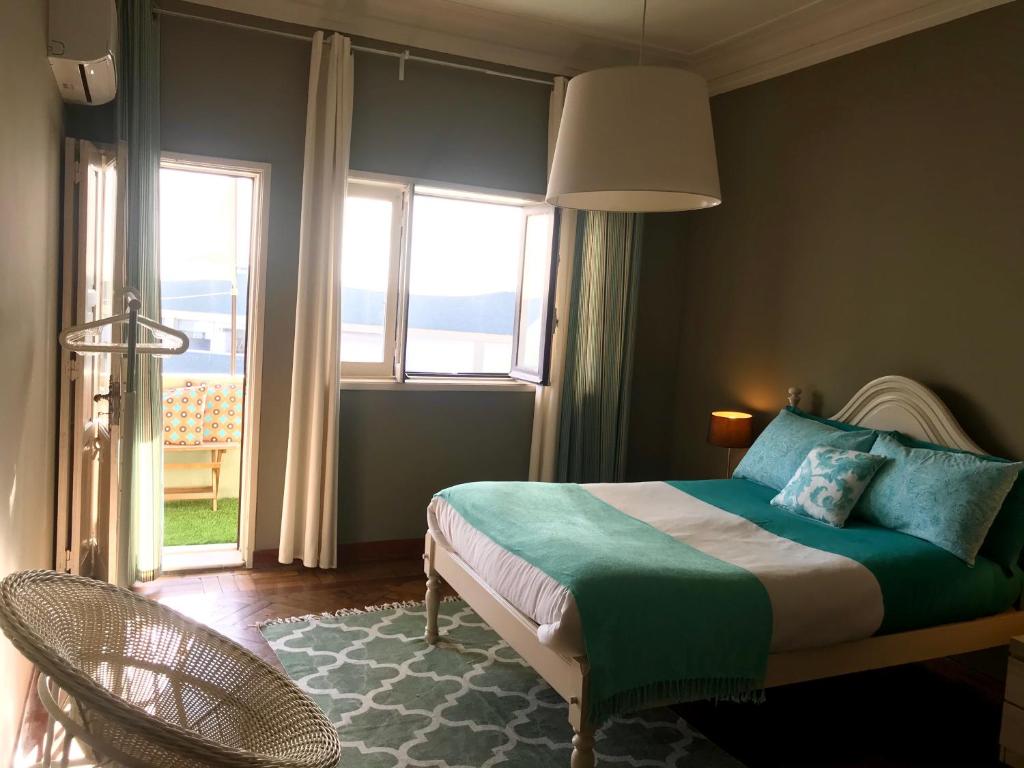 ein Schlafzimmer mit einem Bett und einem großen Fenster in der Unterkunft Apartamento Porto Baixa in Porto