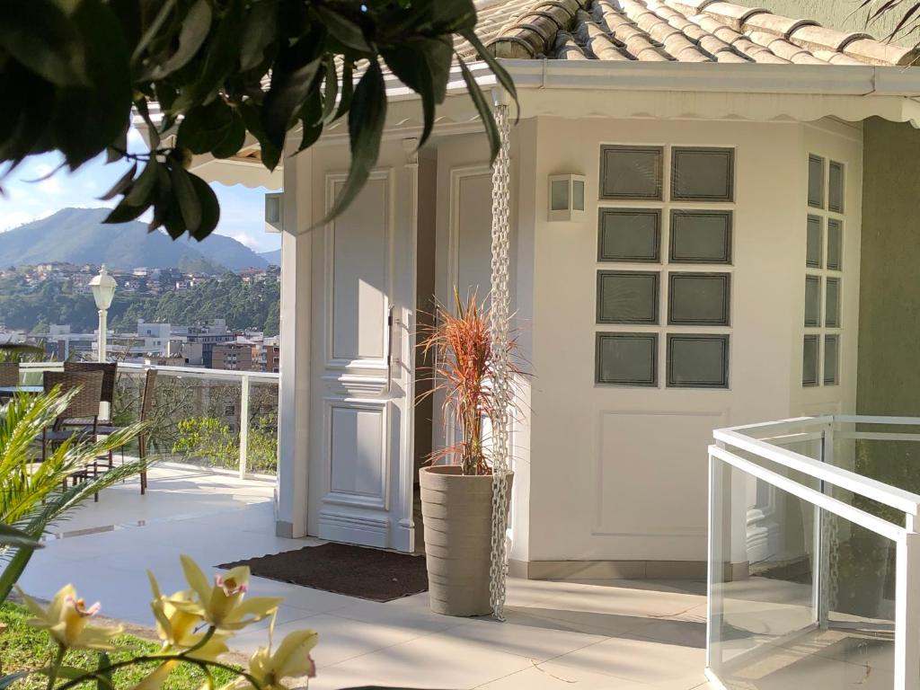 a white door on a house with a balcony at Aconchegante casa com piscina e lazer completo in Teresópolis