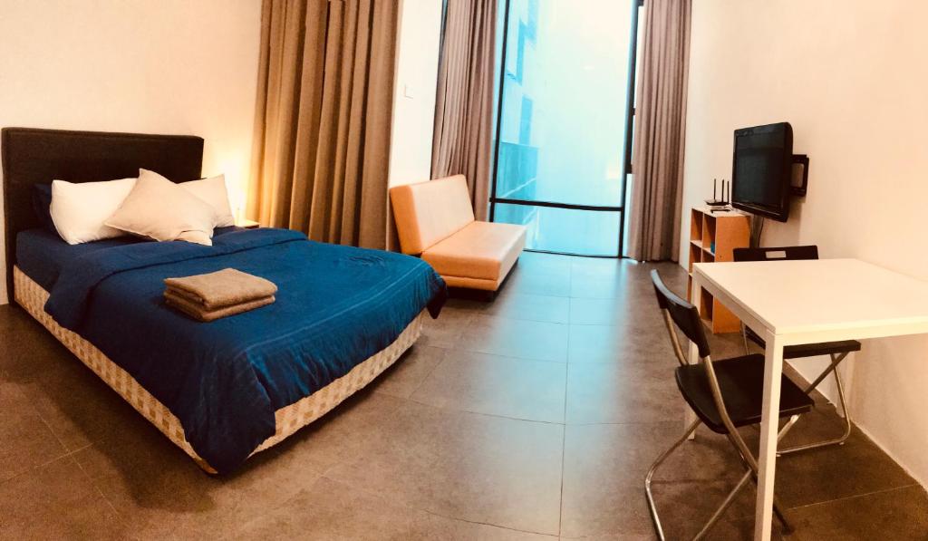 Schlafzimmer mit einem Bett, einem Schreibtisch und einem TV in der Unterkunft Montana Suite 5, Empire Damansara in Petaling Jaya