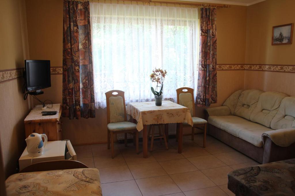 ein Wohnzimmer mit einem Sofa und einem Tisch in der Unterkunft Pokoje Gościnne ASIA in Łeba