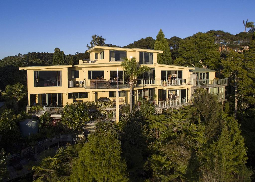 een groot wit huis op een heuvel met bomen bij Allegra House in Paihia