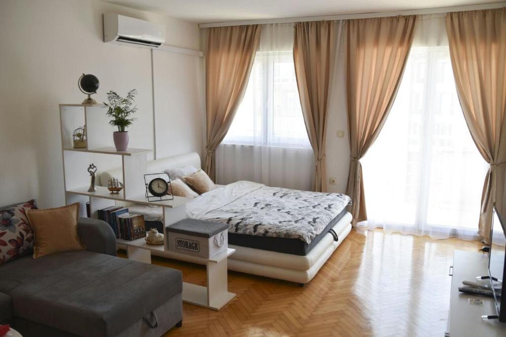 - une chambre avec un lit, une chaise et un canapé dans l'établissement Luna apartman, à Brčko