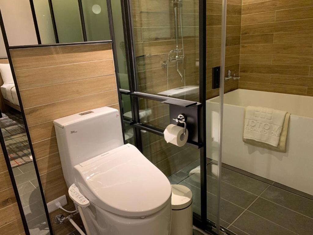 a small bathroom with a toilet and a shower at Hotel Midtown Richardson in Taipei