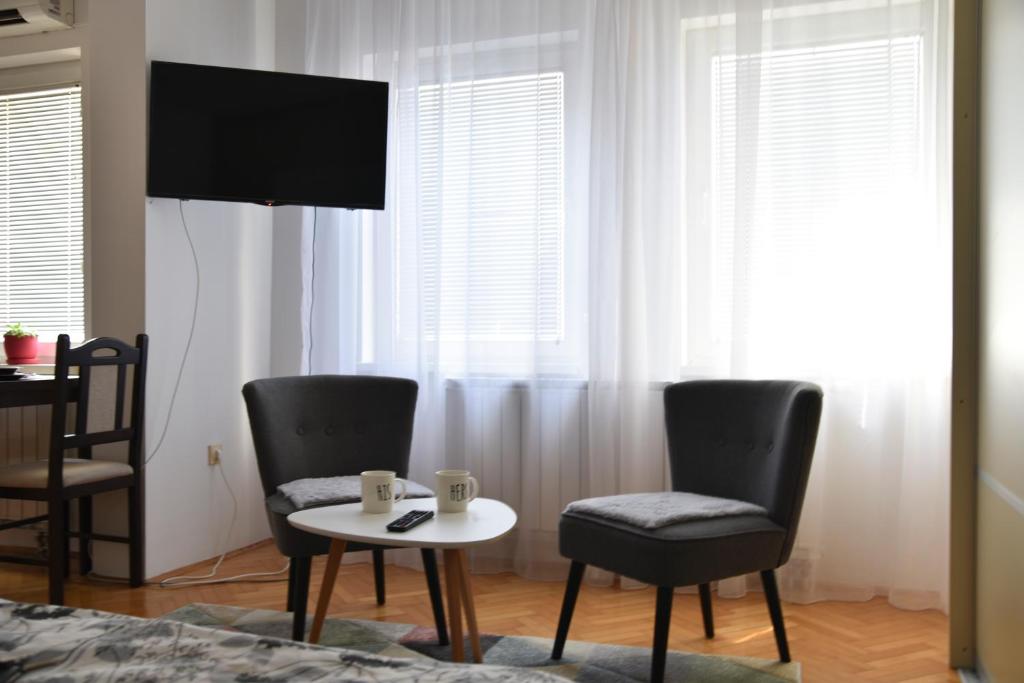 a room with two chairs and a table and a tv at City center in Brčko