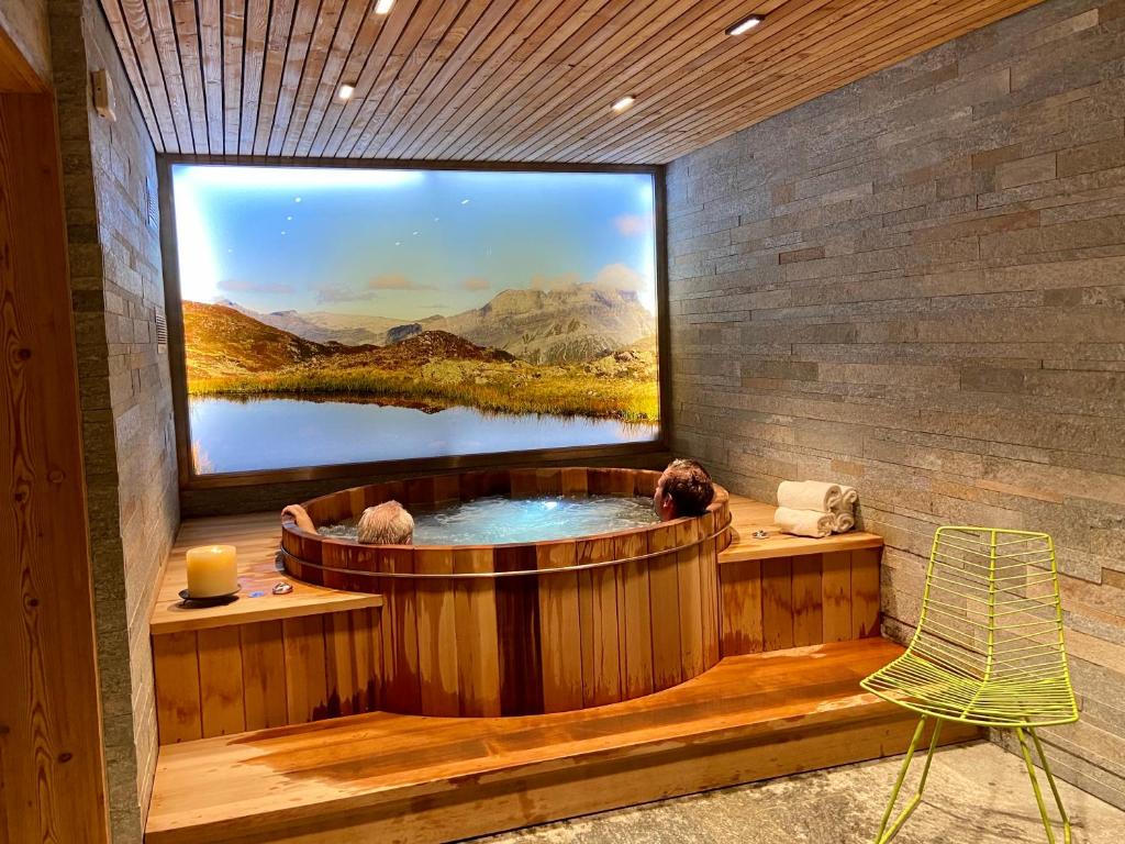 a hot tub with a large window in a room at Hôtel LAPIAZ & Spa - FLAINE in Flaine