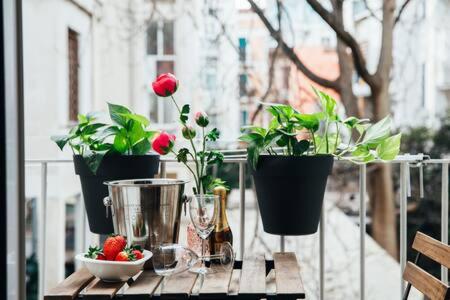 uma mesa com três vasos de plantas e uma taça de morangos em Flores Home em Bari