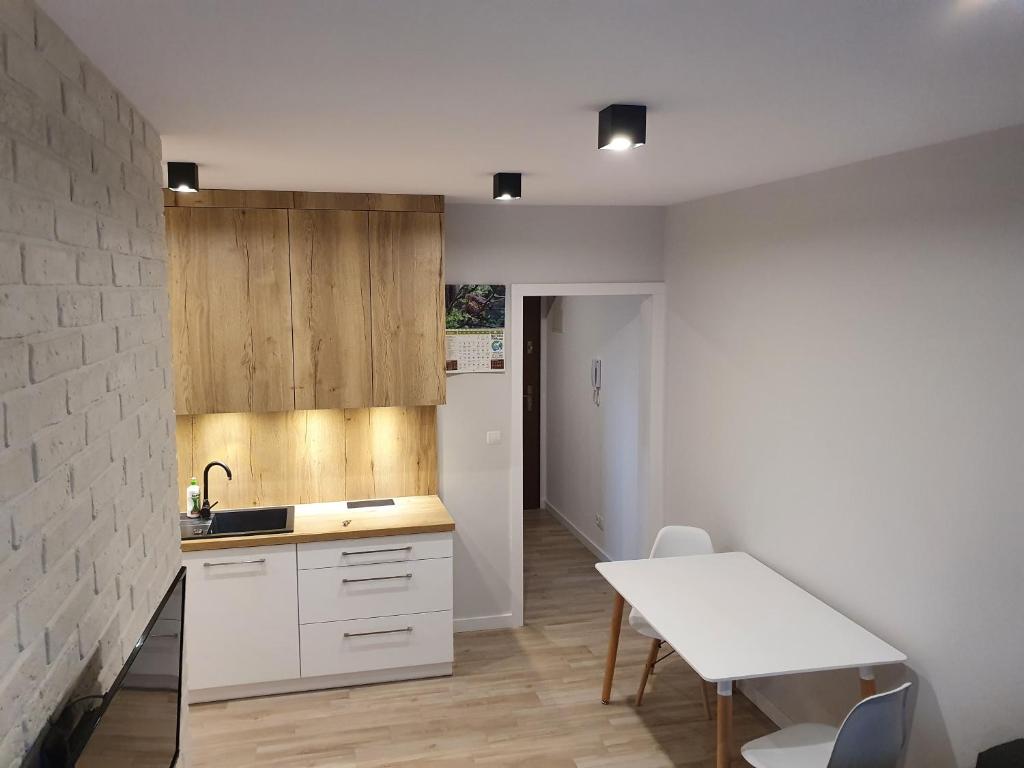 a kitchen with a sink and a table and a counter at Apartament nad Sapiną in Kruklanki
