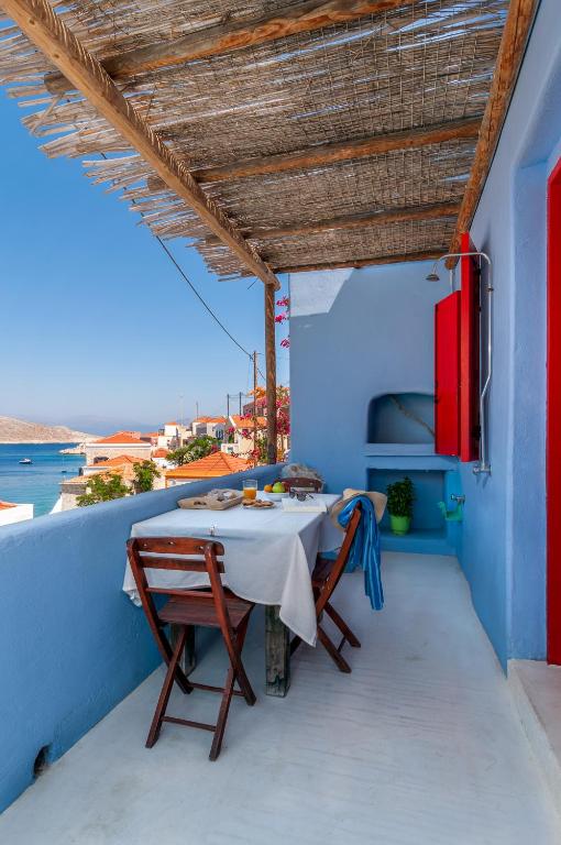 a table on a balcony with a view of the ocean at Atlantis Houses in Halki