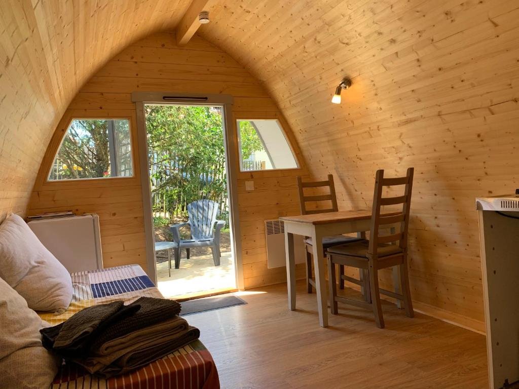a room with a table and chairs in a cabin at Hébergement insolite homes d Opale in Saint-Martin-Boulogne