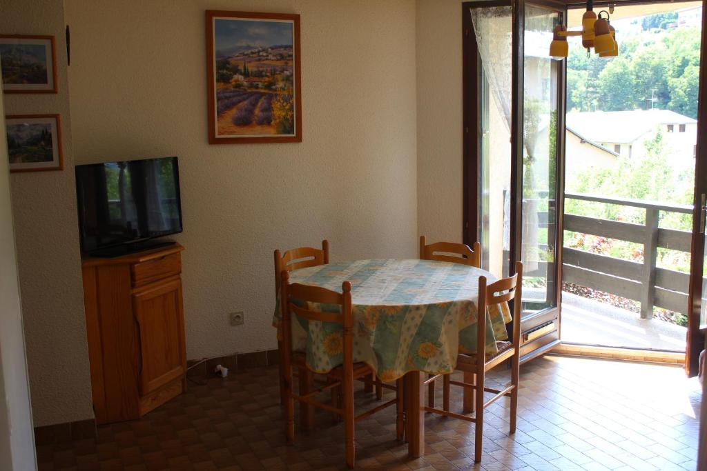 a dining room with a table and a television at Appartement au calme, à deux pas du plan d eau in Embrun