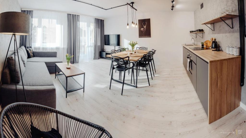 een keuken en een woonkamer met een tafel en stoelen bij Apartament Centrum 2 sypialnie i salon in Szklarska Poręba