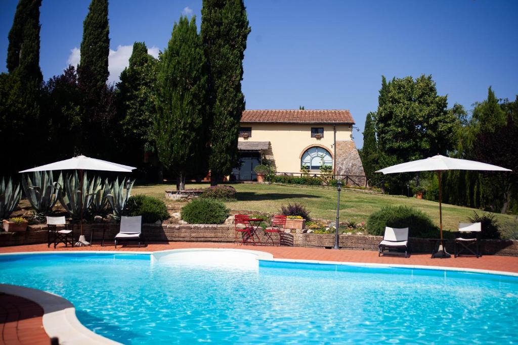 una casa y una piscina con sillas y sombrillas en Casa vacanze Casalsole, en Vinci