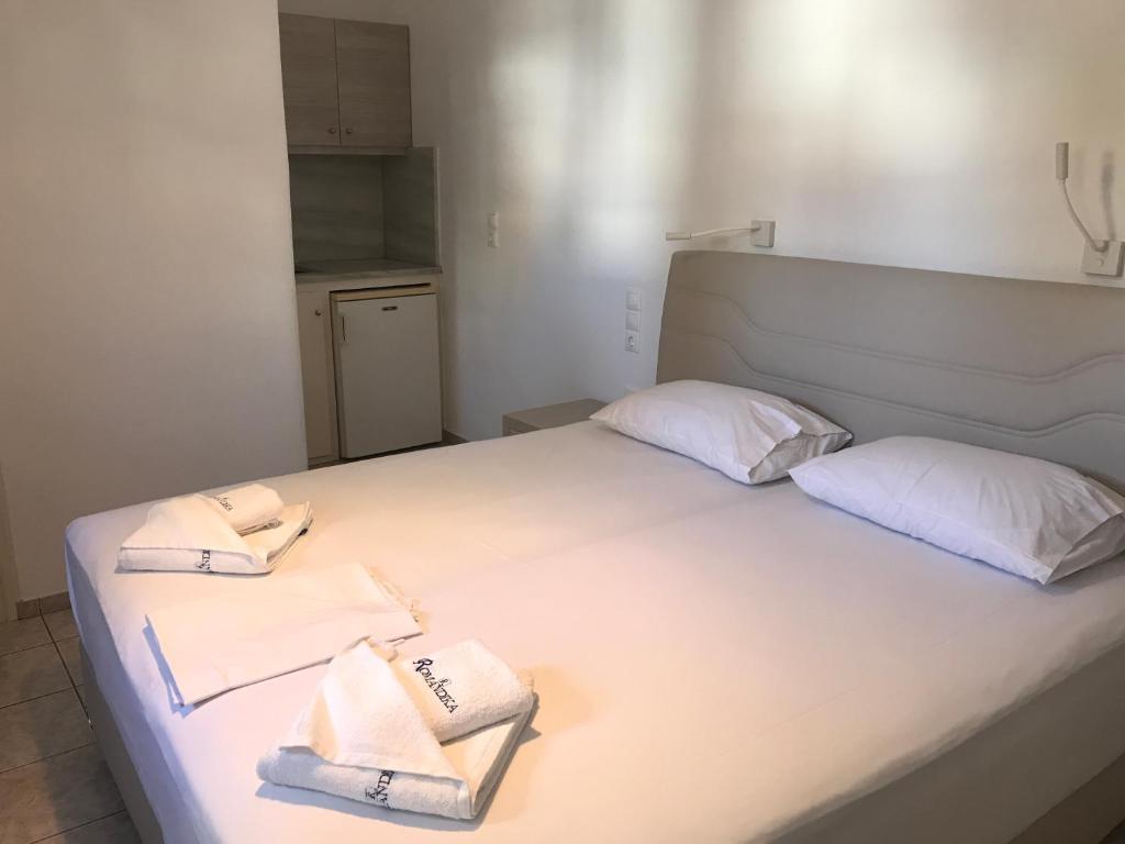 a white bed with two towels on top of it at Romantika in Platis Gialos