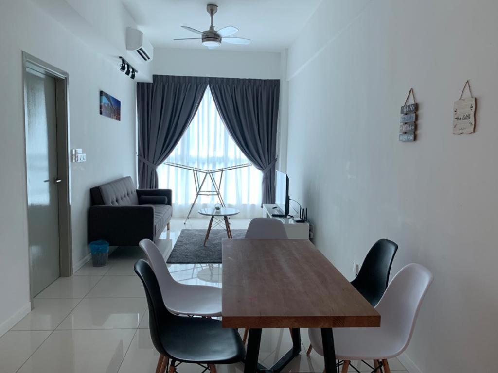 a dining table and chairs in a living room at FLYPOD - Blue Sky Apartment 4-5pax , Sutera Avenue in Kota Kinabalu