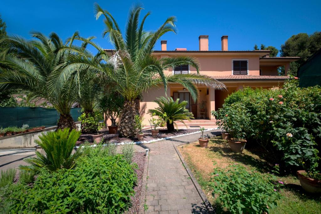 a house with palm trees in front of it at Villa Alida Casa Vacanze in Foligno