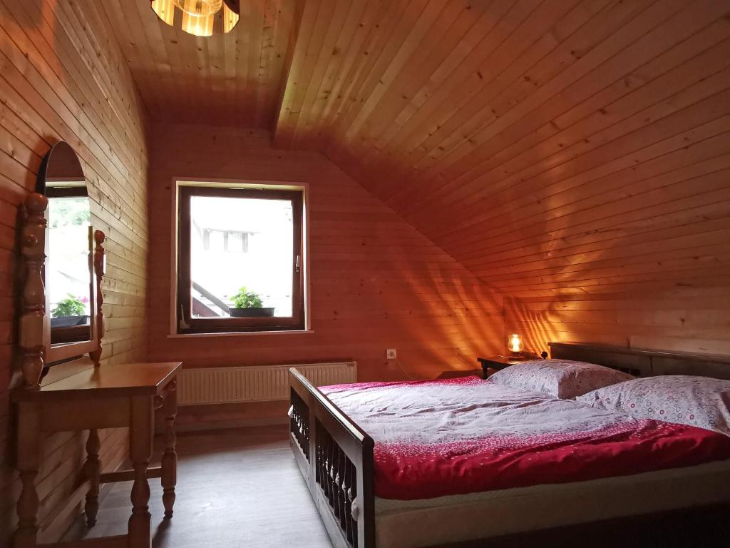 a bedroom with a bed in a wooden room at Apartment V&N, LAKE BOHINJ in Bohinj