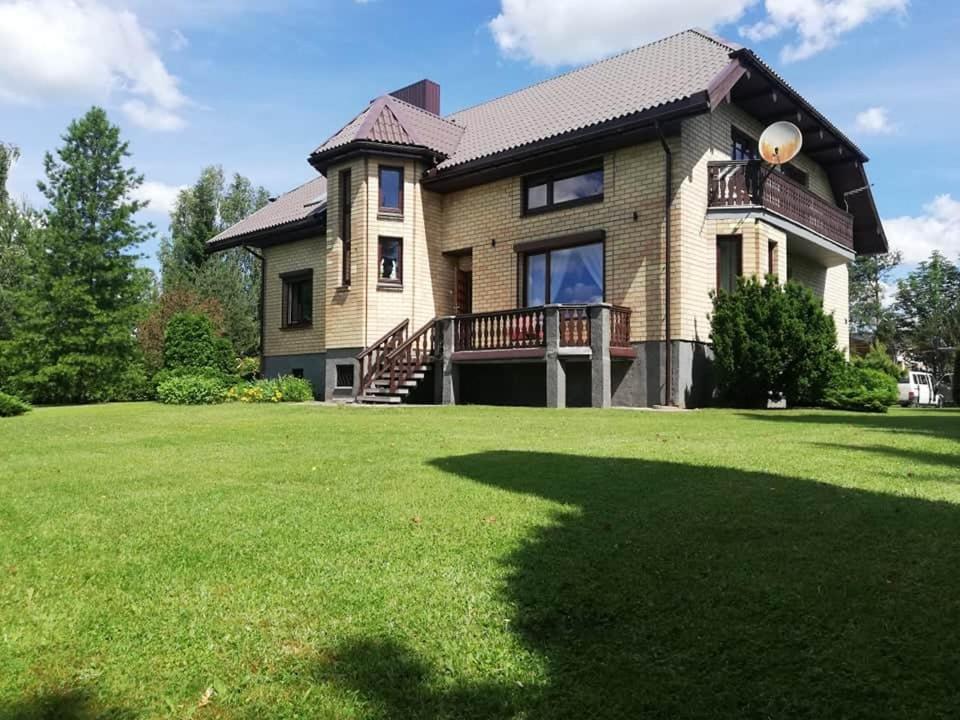 uma casa grande com um grande relvado em frente em Ramus poilsis prie Širvintų marių em Širvintos