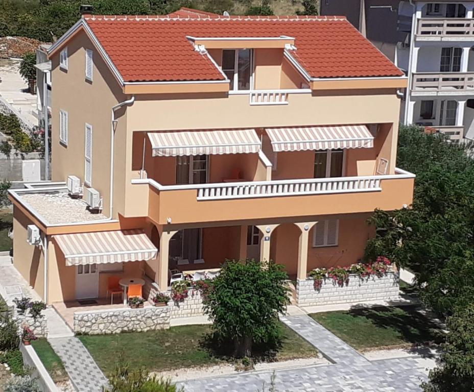 a large house with a red roof at Apartmani Ruža in Novalja