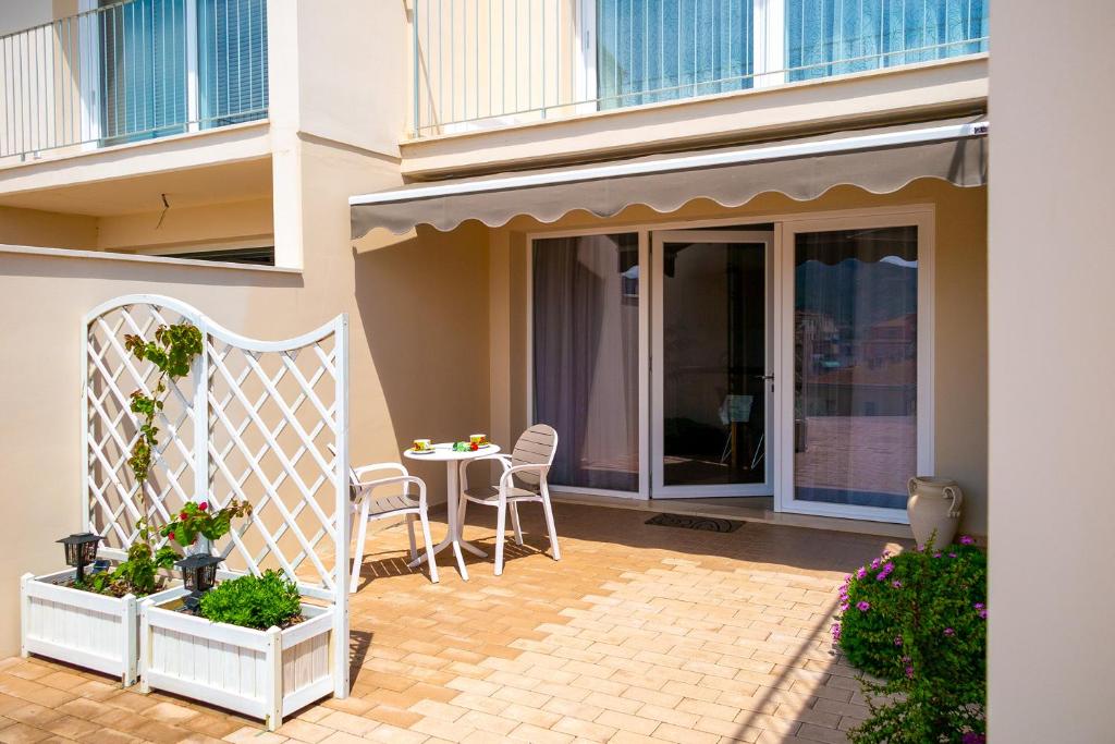 een patio met een tafel en stoelen in een gebouw bij Appartamento Vicino al Mare in Portoferraio