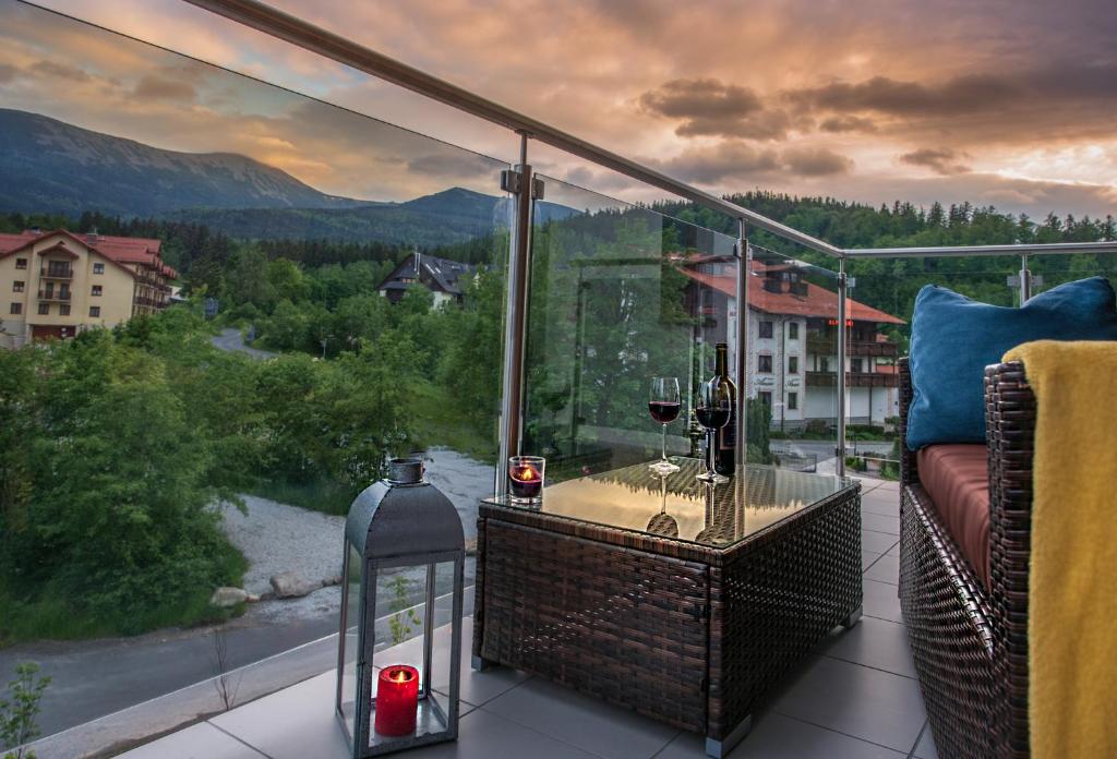 a balcony with a table with wine glasses on it at Apartament MOUNTSEA ,Karpacz Ogrodnicza in Karpacz