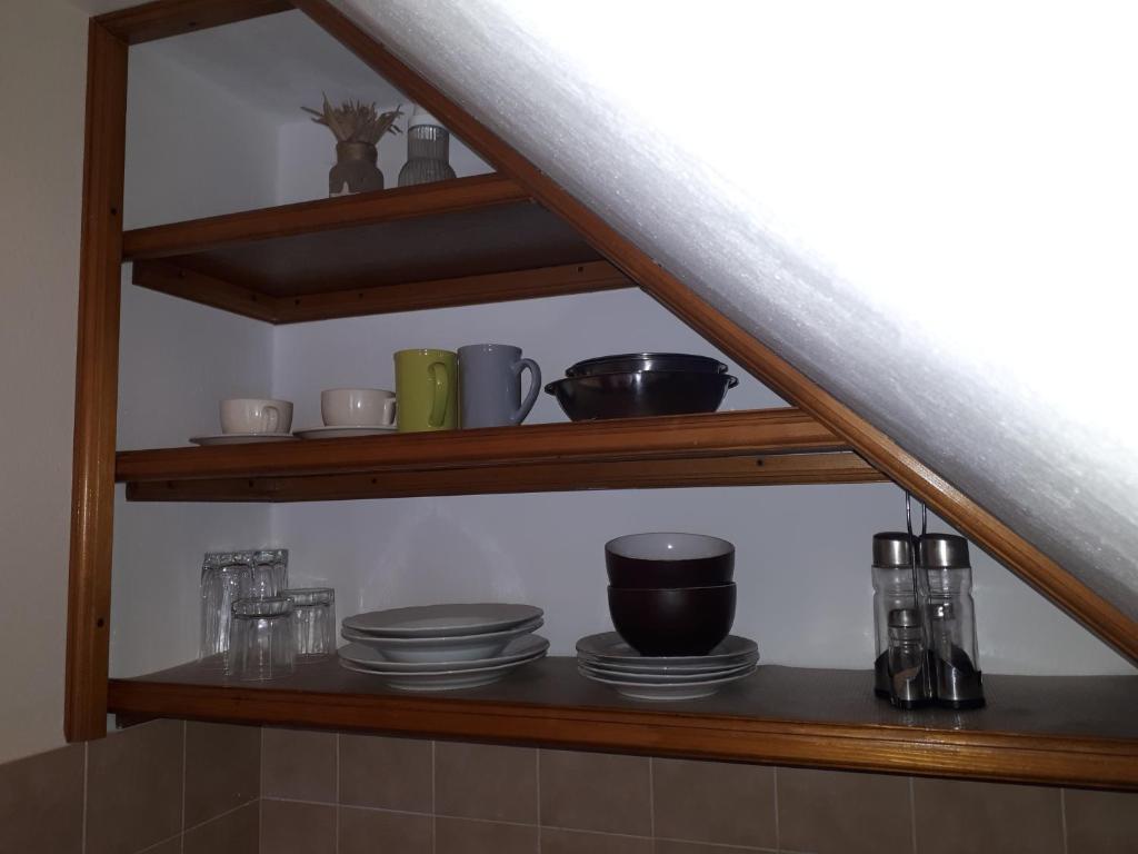 une étagère avec des tasses et de la vaisselle dans l'établissement Studio with balcony, à Jelsa