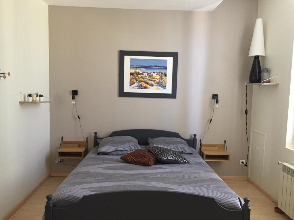 a bedroom with a bed with two pillows on it at le patio de l'oustal in Gimont