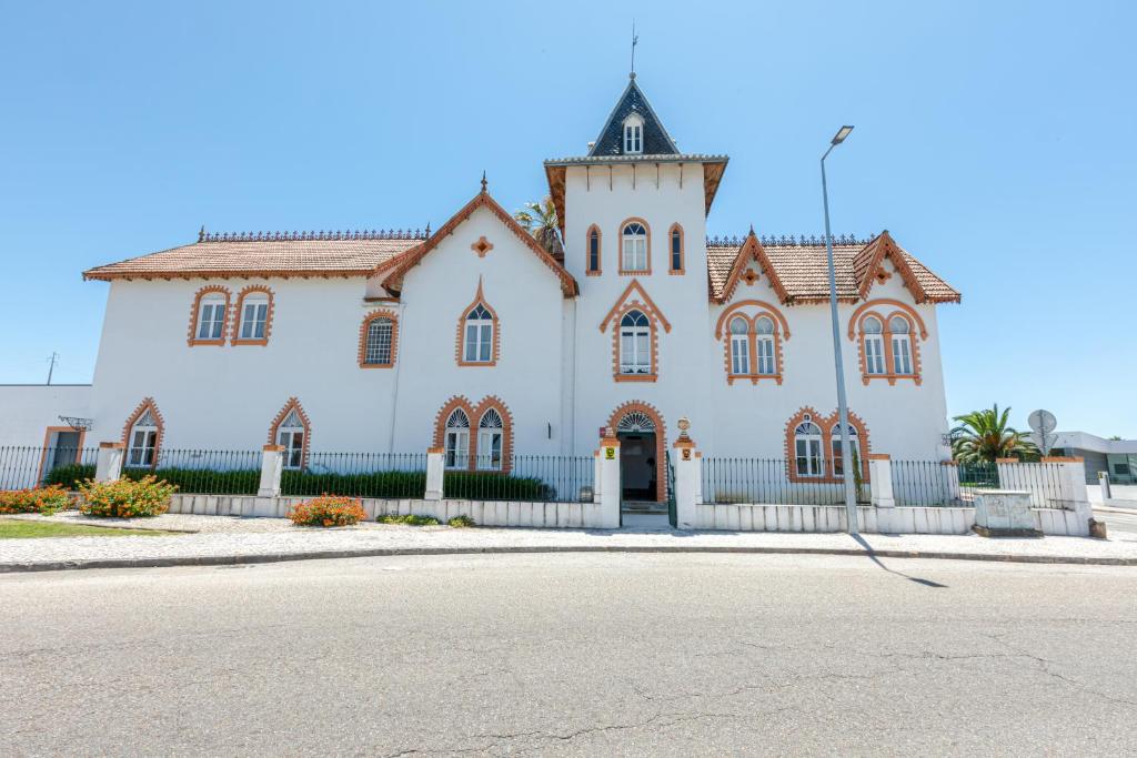 duży biały budynek z wieżą zegarową w obiekcie Dona Amélia w mieście Abrantes
