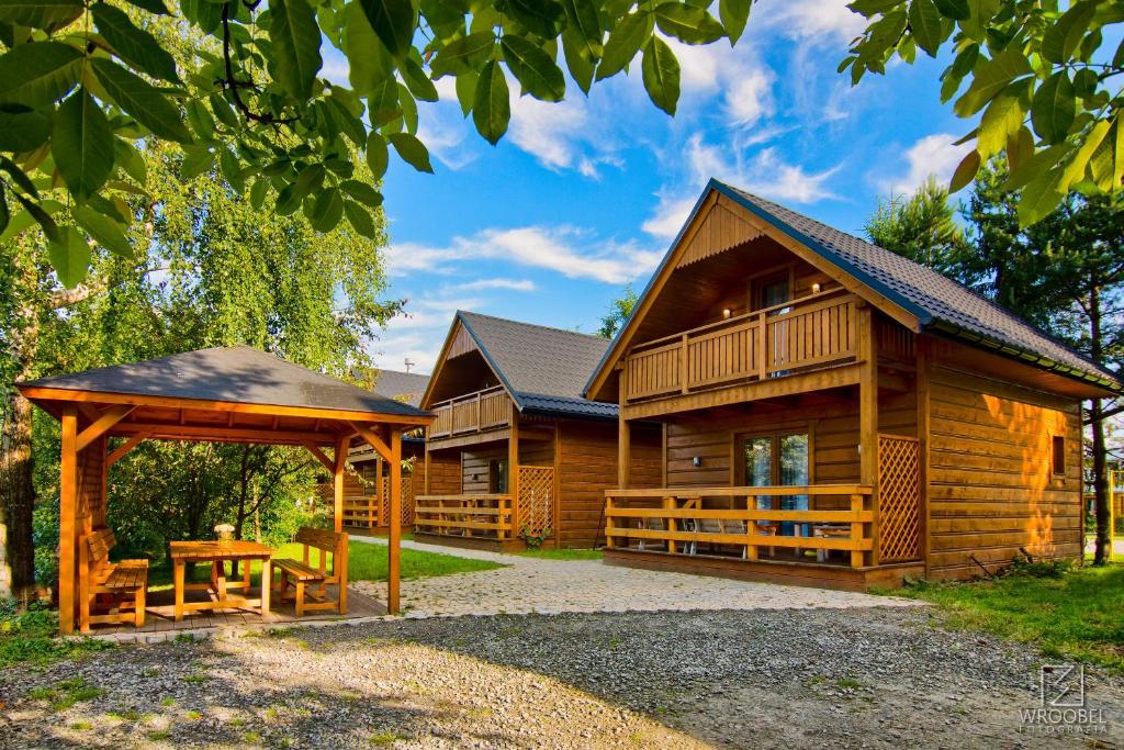 eine Blockhütte mit einem Tisch und einem Pavillon in der Unterkunft Domki Skiba Szaflary in Szaflary