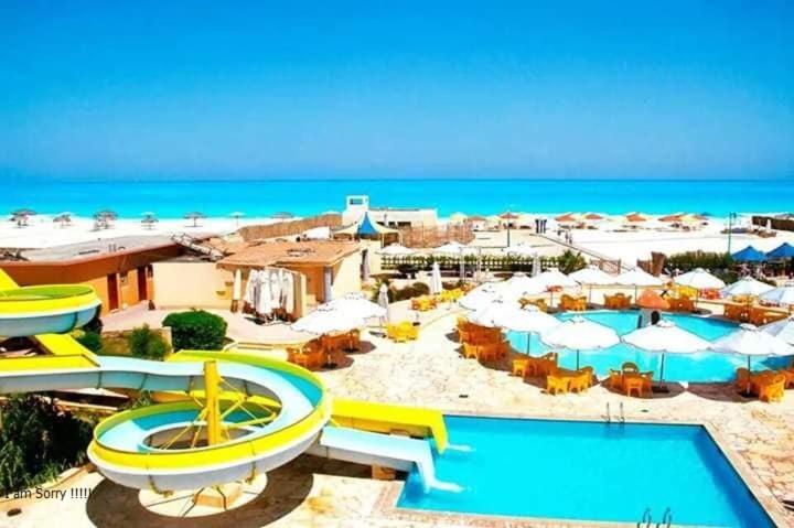 un complejo con piscina y playa en Green Leaves Hotel en Dawwār Abū Duray‘ah ‘Abd al Karīm