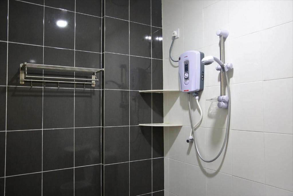 eine Dusche im Bad mit einem Telefon an der Wand in der Unterkunft Camlodge Budget Hotel in Cameron Highlands