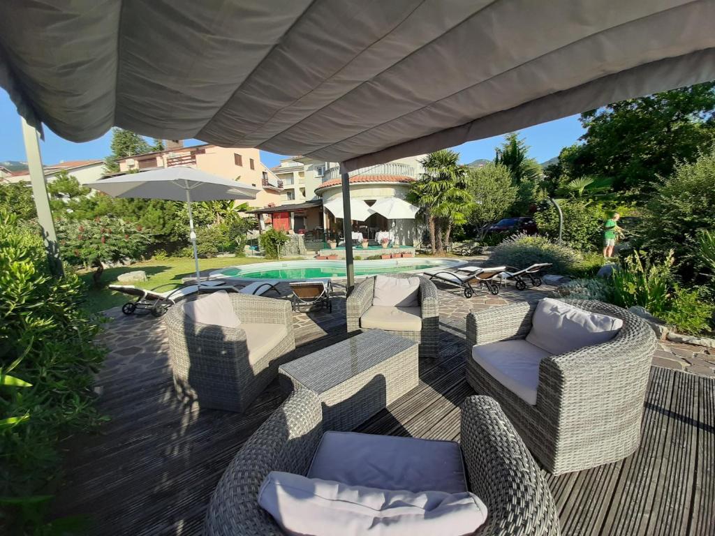 een patio met stoelen, een parasol en een zwembad bij B&B Eva in Ičići