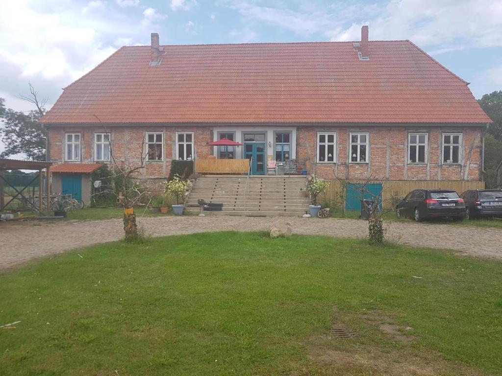a large brick house with a red roof at Gutshaus Pinnow in Pinnow