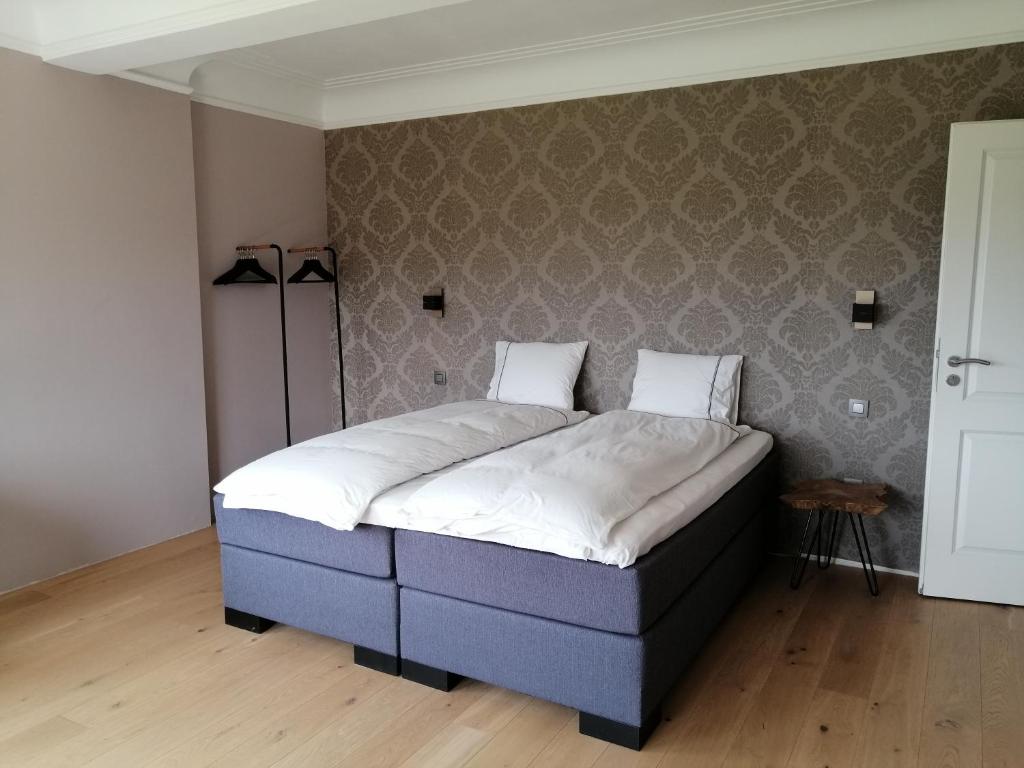 1 cama en un dormitorio con pared en La Roseraie, en Stavelot