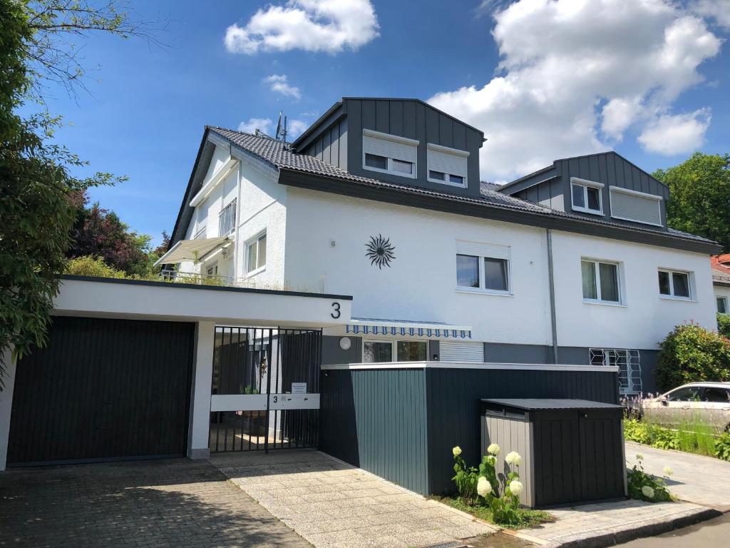 una casa blanca con garaje negro en Sonnenhaus, en Sindelfingen